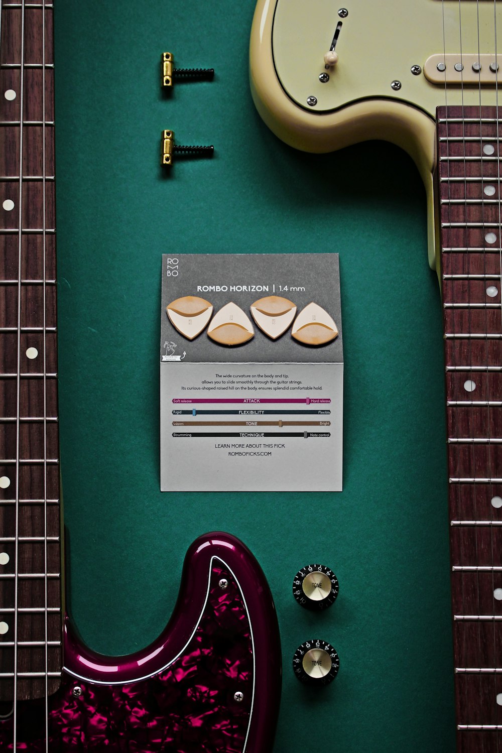 Una chitarra elettrica e un accordatore per chitarra su una superficie  verde foto – Grigio Immagine gratuita su Unsplash