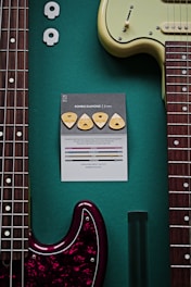 a guitar and a note on a green surface