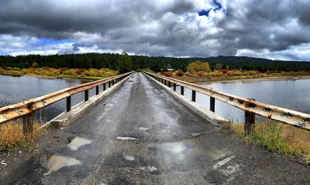 a bridge over a body of water under a cloudy sky