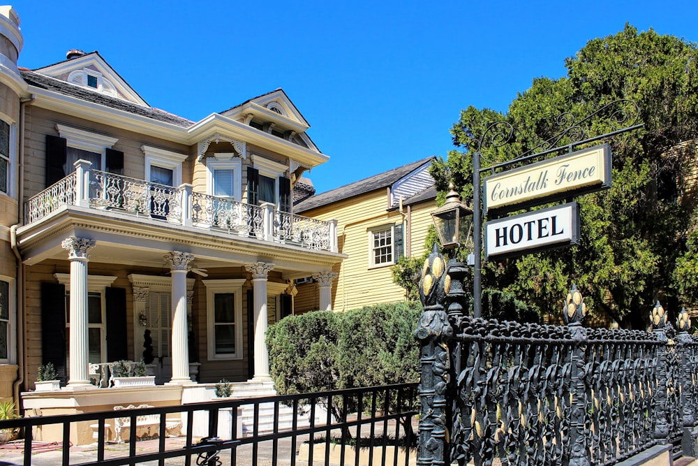 a hotel sign is posted on a wrought iron fence