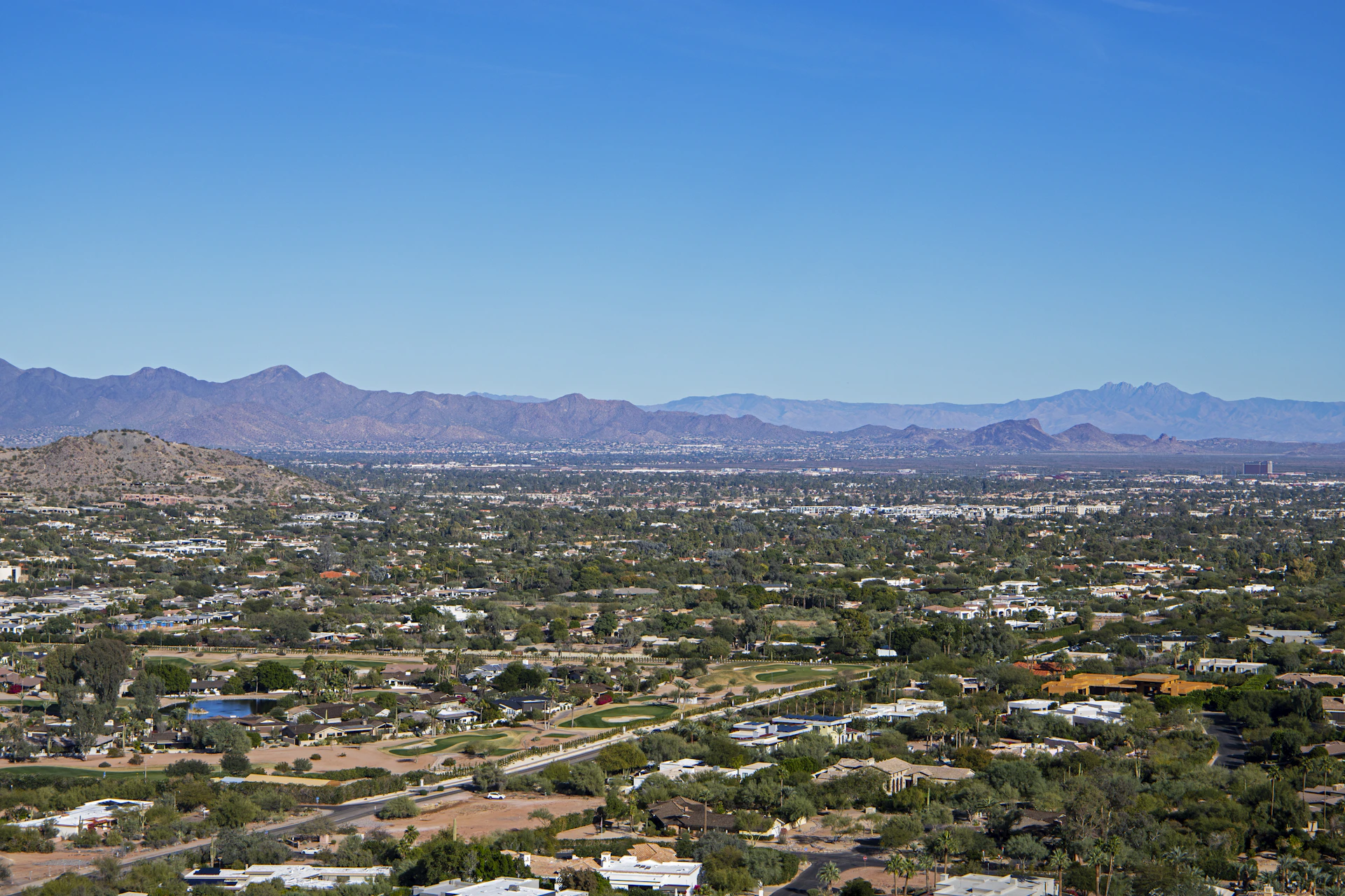 an aerial view of a city with mountains in the background