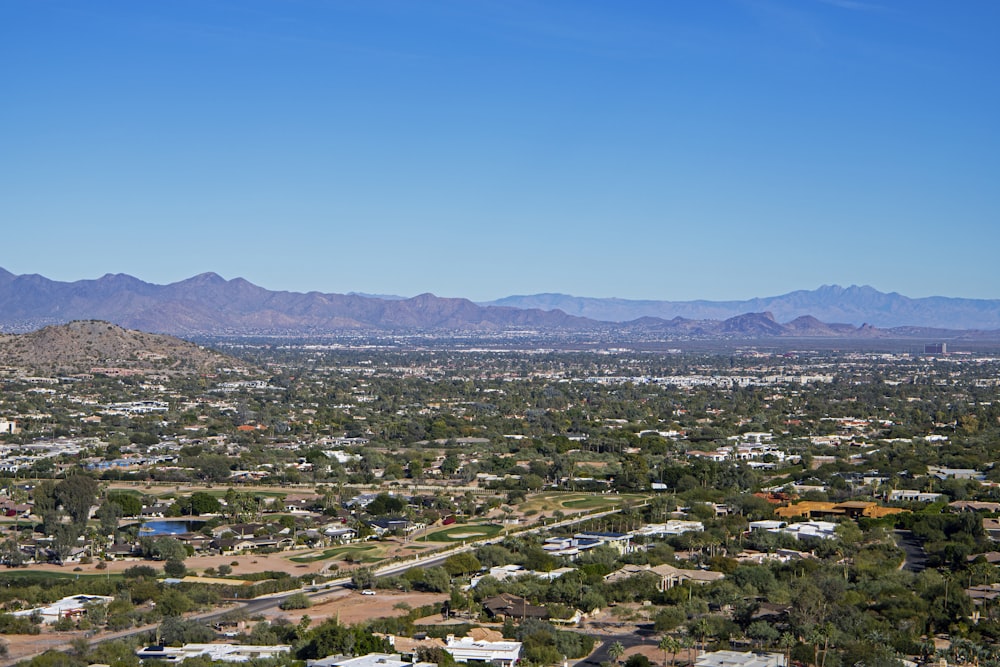 an aerial view of a city with mountains in the background