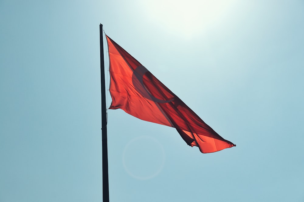 a red flag flying high in the sky