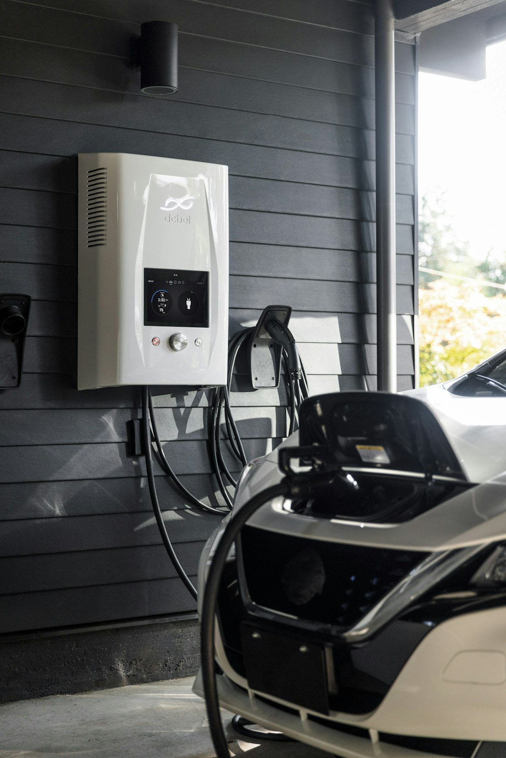 an electric car plugged into a charger in a garage
