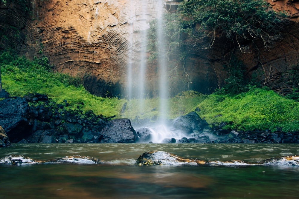 a waterfall with a waterfall cascading down it's side