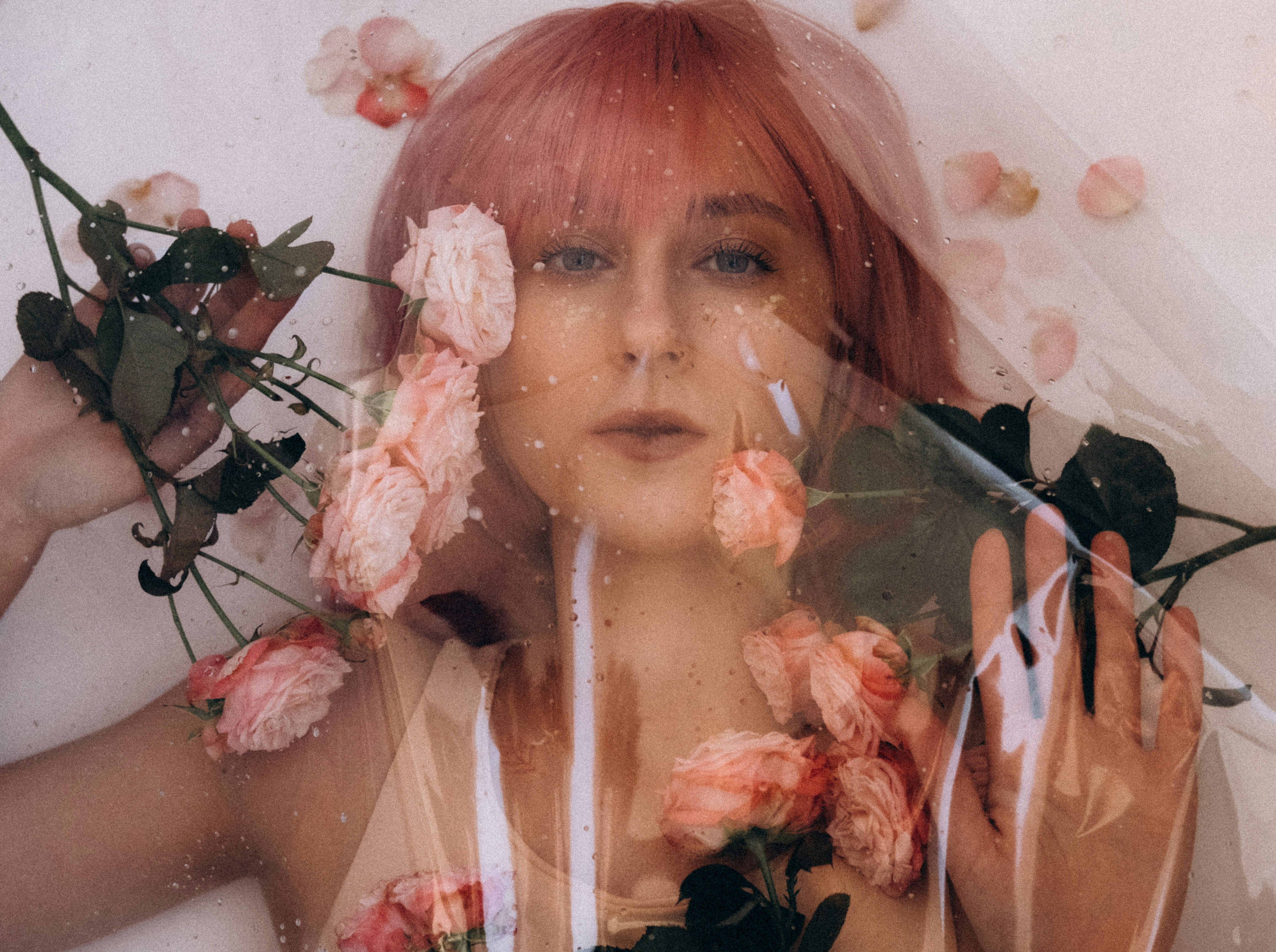 a woman in a bathtub with flowers around her