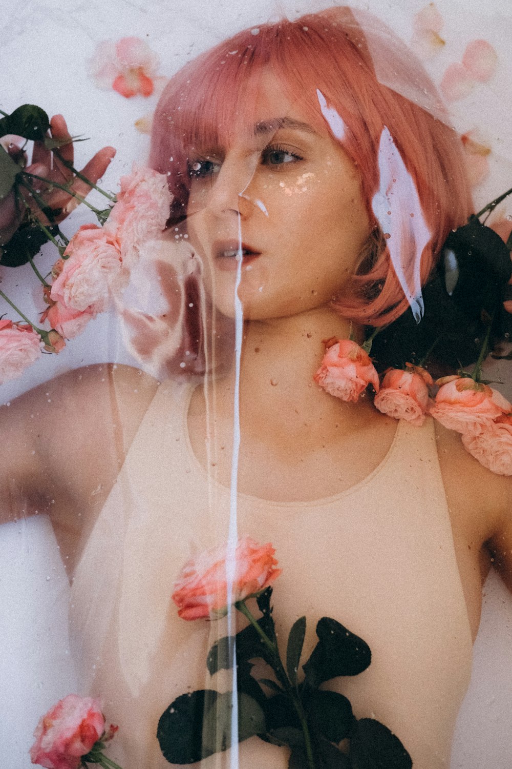 a woman with pink hair and flowers in her hair