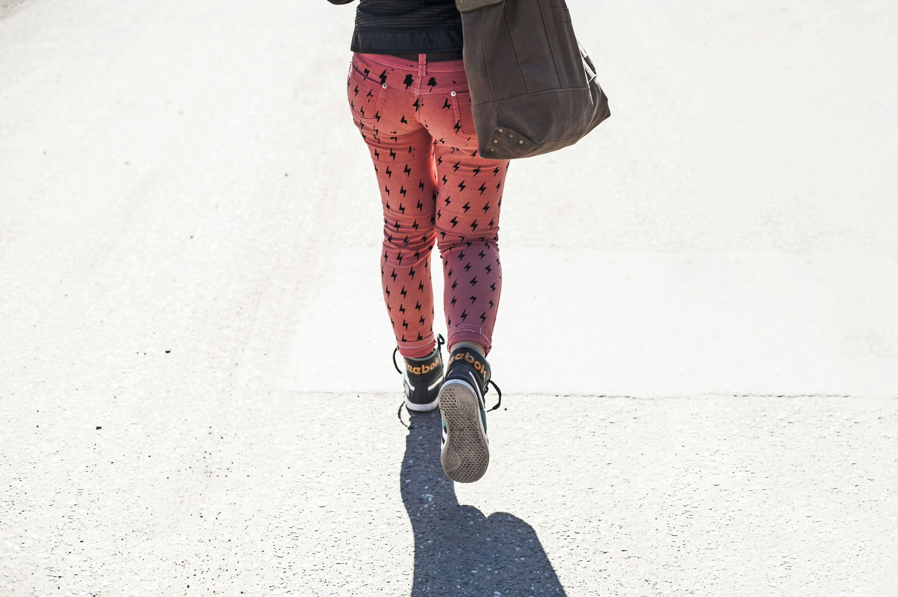 a woman walking down a street while talking on a cell phone