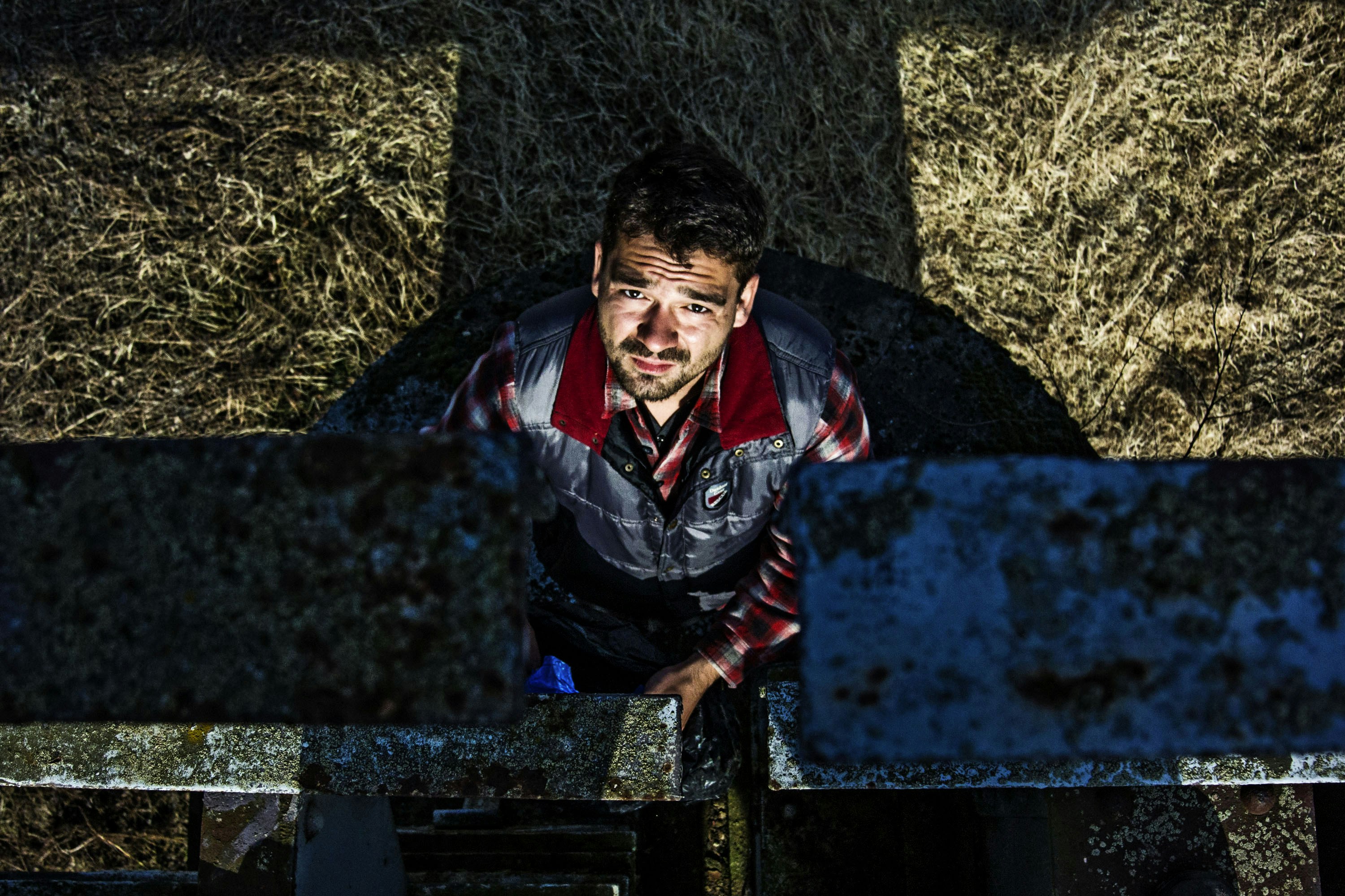 Un homme debout devant un tas de foin