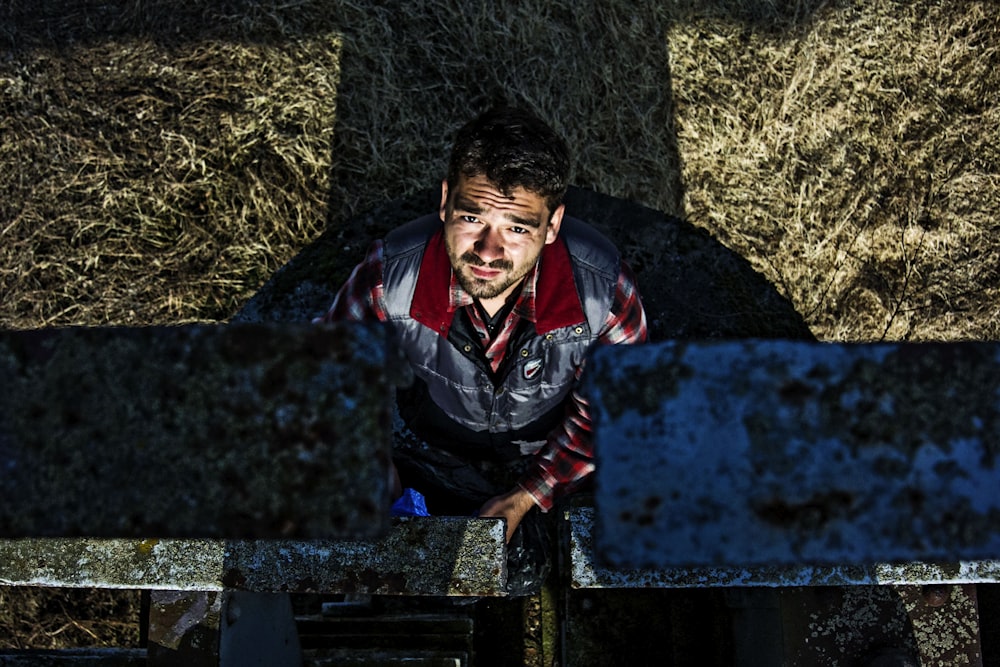 a man standing in front of a pile of hay