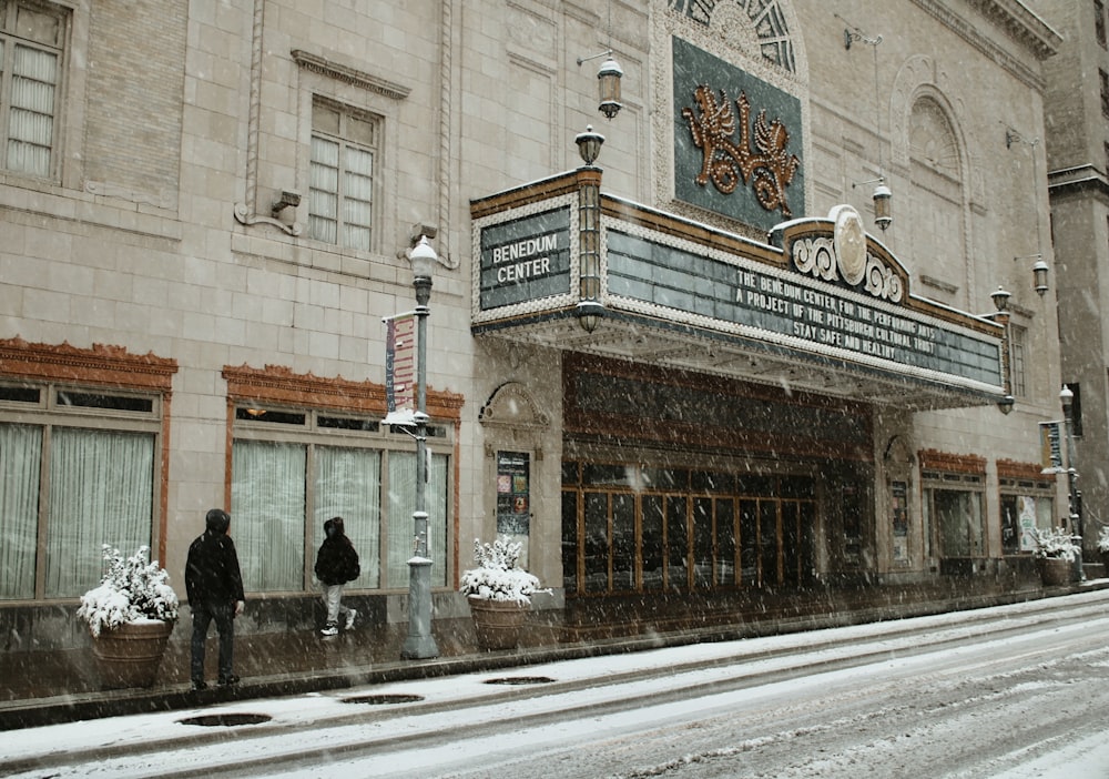 a movie theater on a snowy street corner