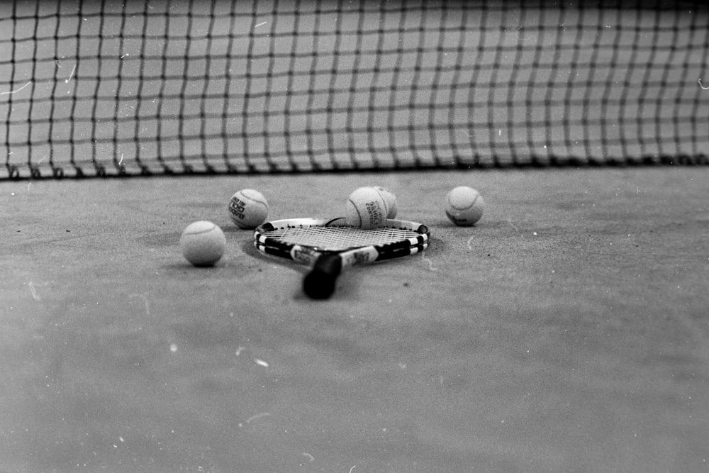 a black and white photo of a tennis racket and balls