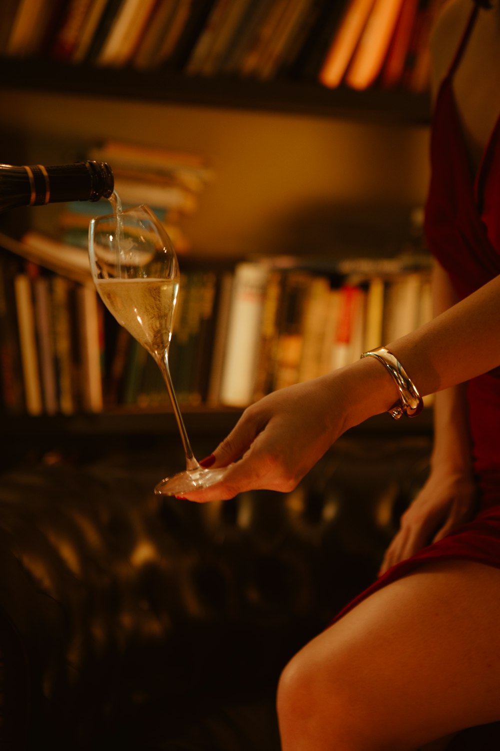 a woman in a red dress holding a wine glass