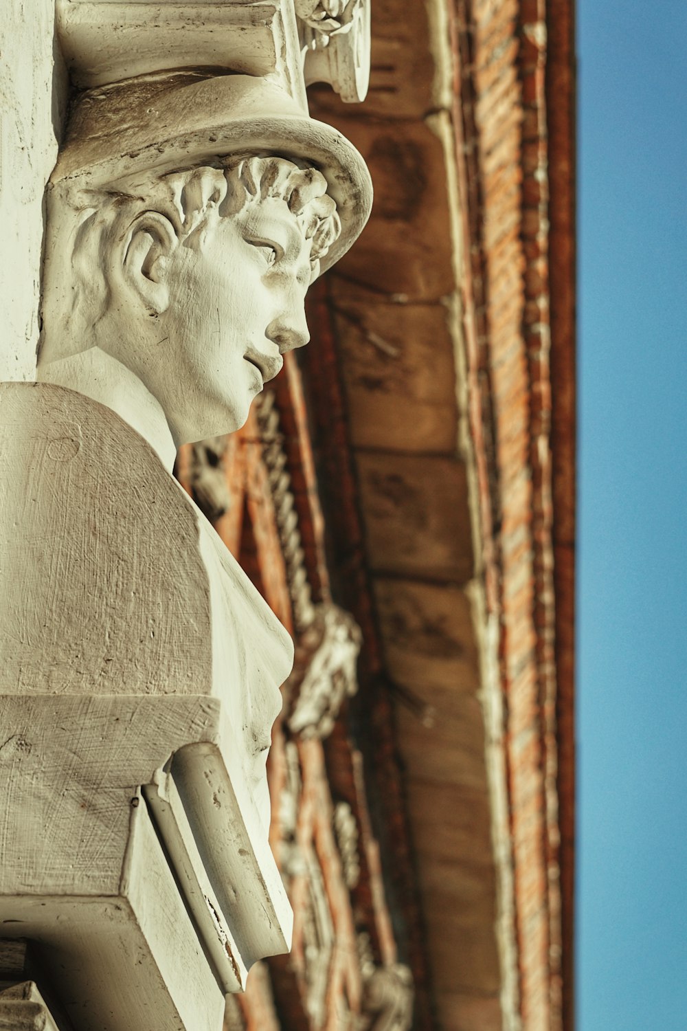 Un primo piano di una statua di un uomo che indossa un cappello