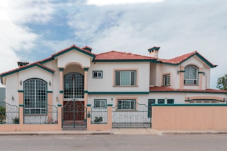a pink and white house with a red roof