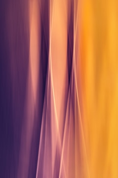 Abstract vertical waves of light in gradient hues blend seamlessly from purple to yellow, creating a soft, flowing appearance.
