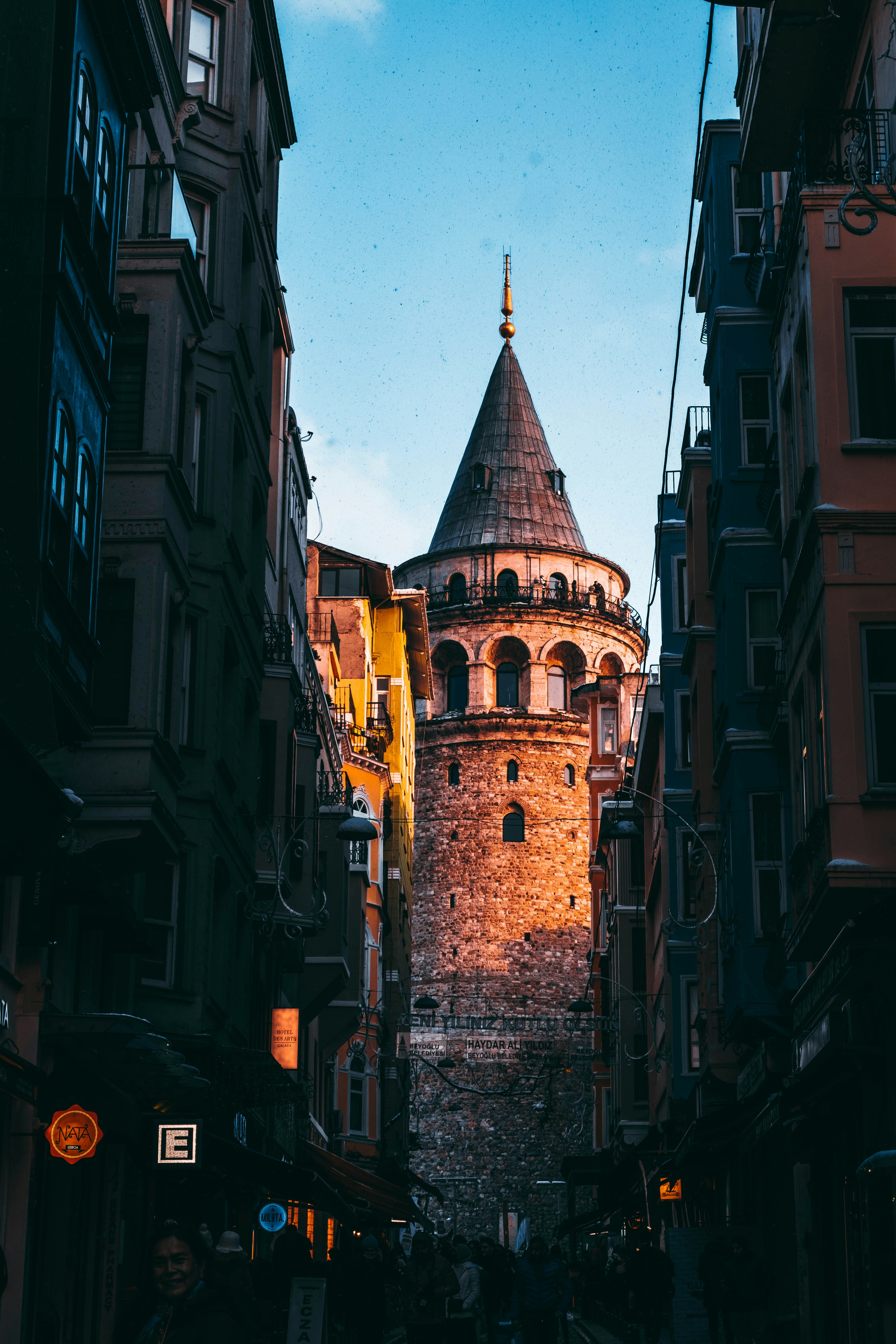 a tall tower towering over a city next to tall buildings