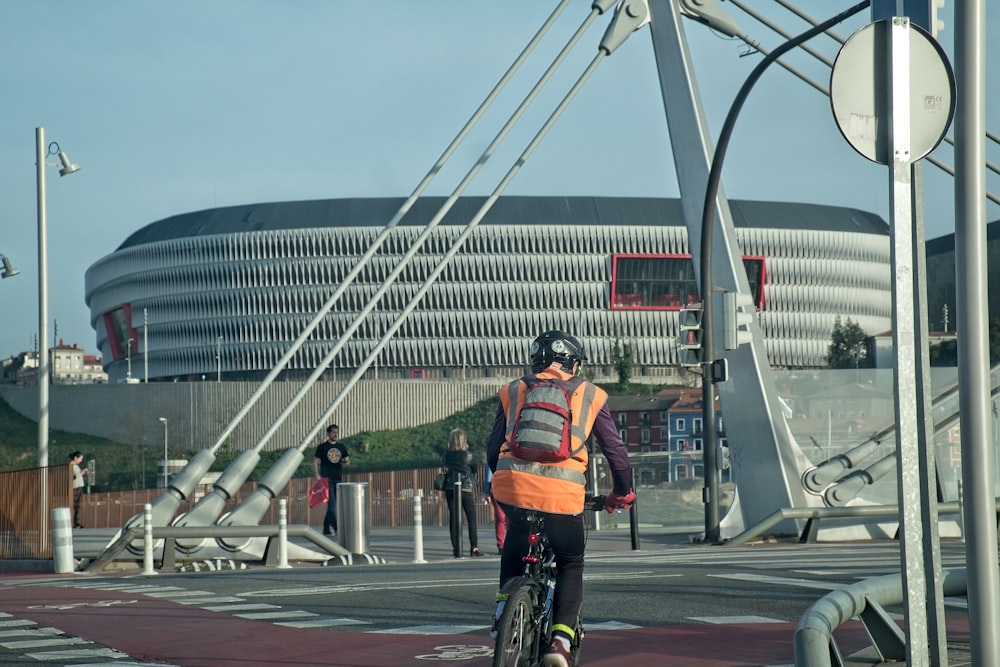 a man riding a bike down a street next to a tall building