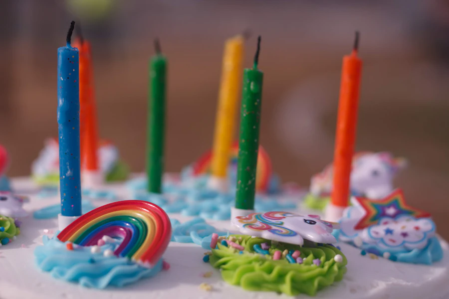 Pastel de cumpleaños con velas de colores y un arcoíris