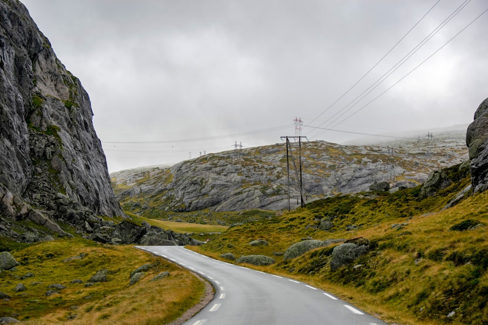 a winding road in the mountains with power lines above