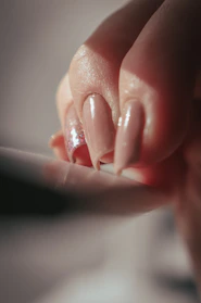 Close-up of glossy black coffin-shaped press-on nails with subtle gold accents.