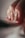 A close-up of a person's hand focusing on their polished nails. The nails are painted in a glossy, neutral color with one nail featuring a hint of glitter. The lighting creates soft shadows, enhancing the textures of the fingers and nails.
