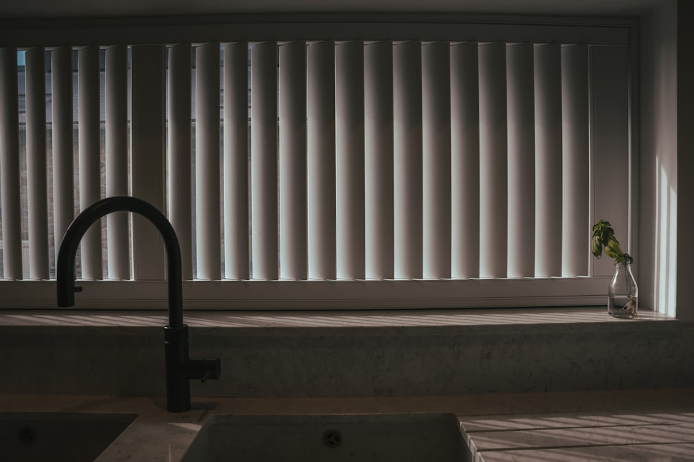 a kitchen sink with a faucet next to a window