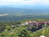 A drone shot showcasing a sprawling mountain resort surrounded by lush greenery.
