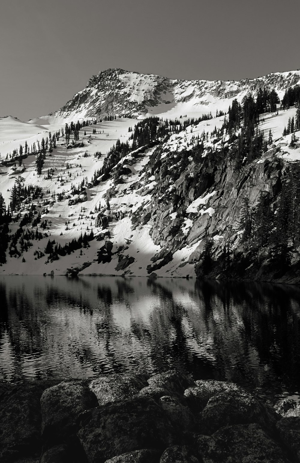 a black and white photo of a snow covered mountain