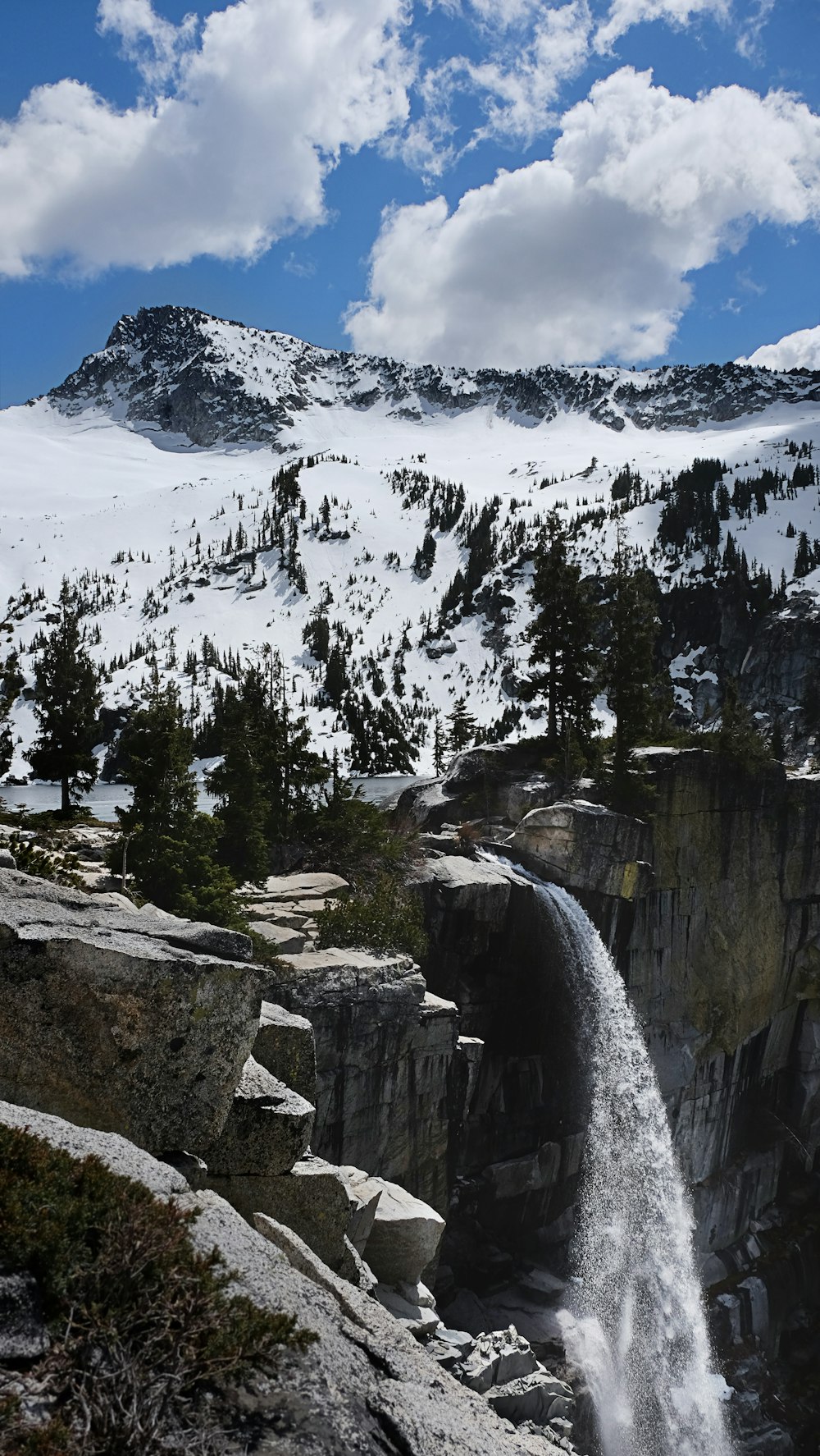 a waterfall in the middle of a snowy mountain