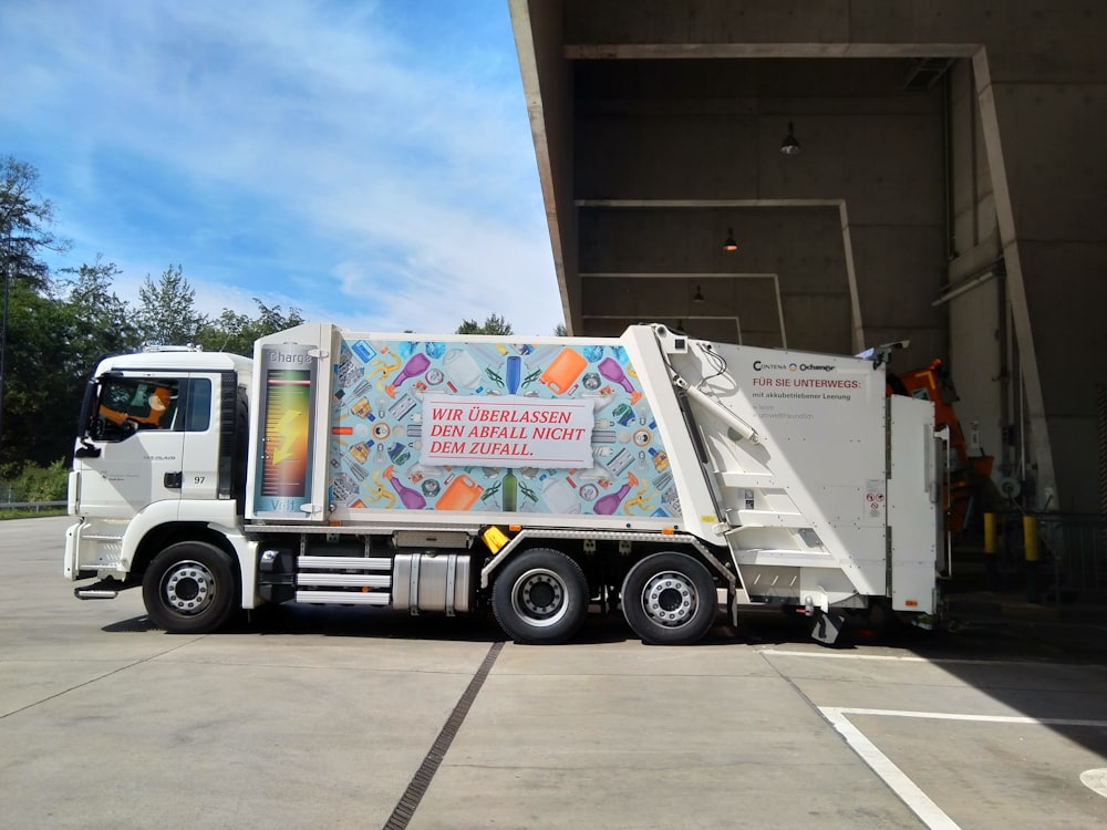 a garbage truck parked in front of a building