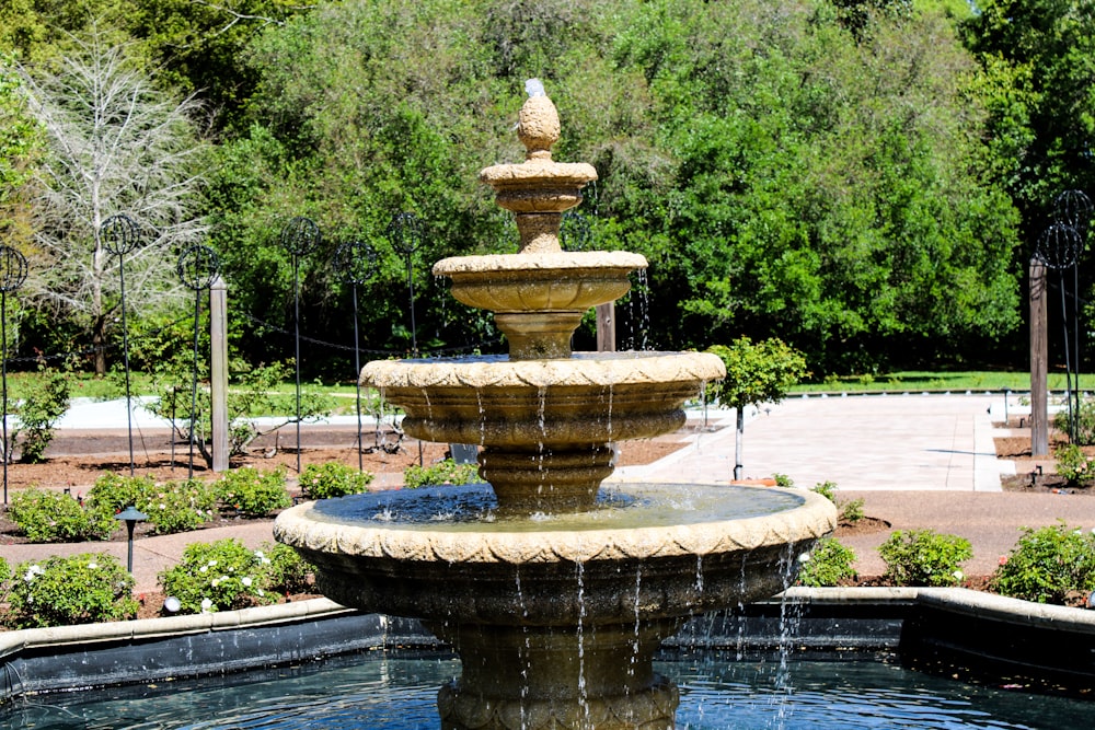 a water fountain in a park with trees in the background