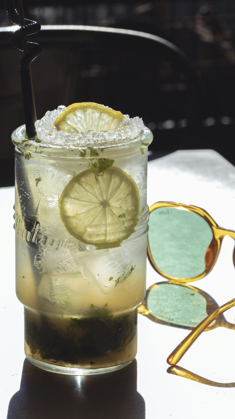 a glass with a lemon and a straw on a table