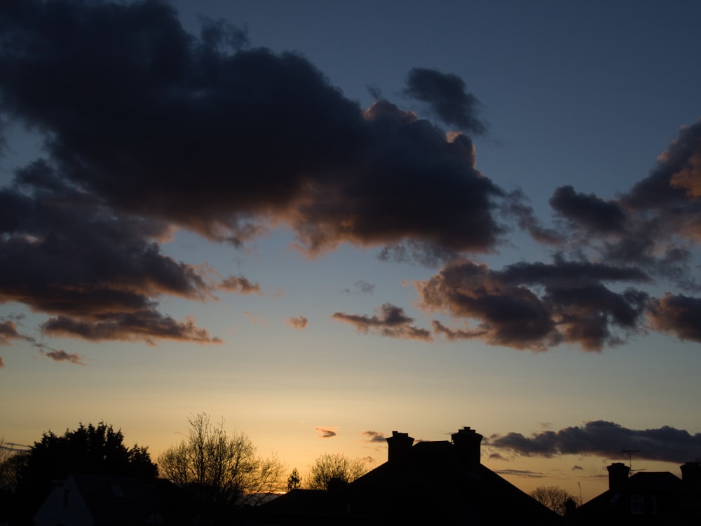 the sun is setting behind some clouds in the sky