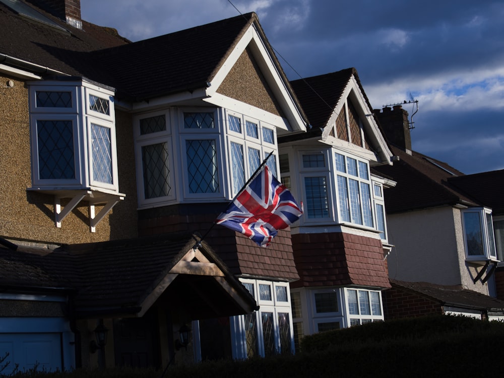 a british flag flying in front of a row of houses