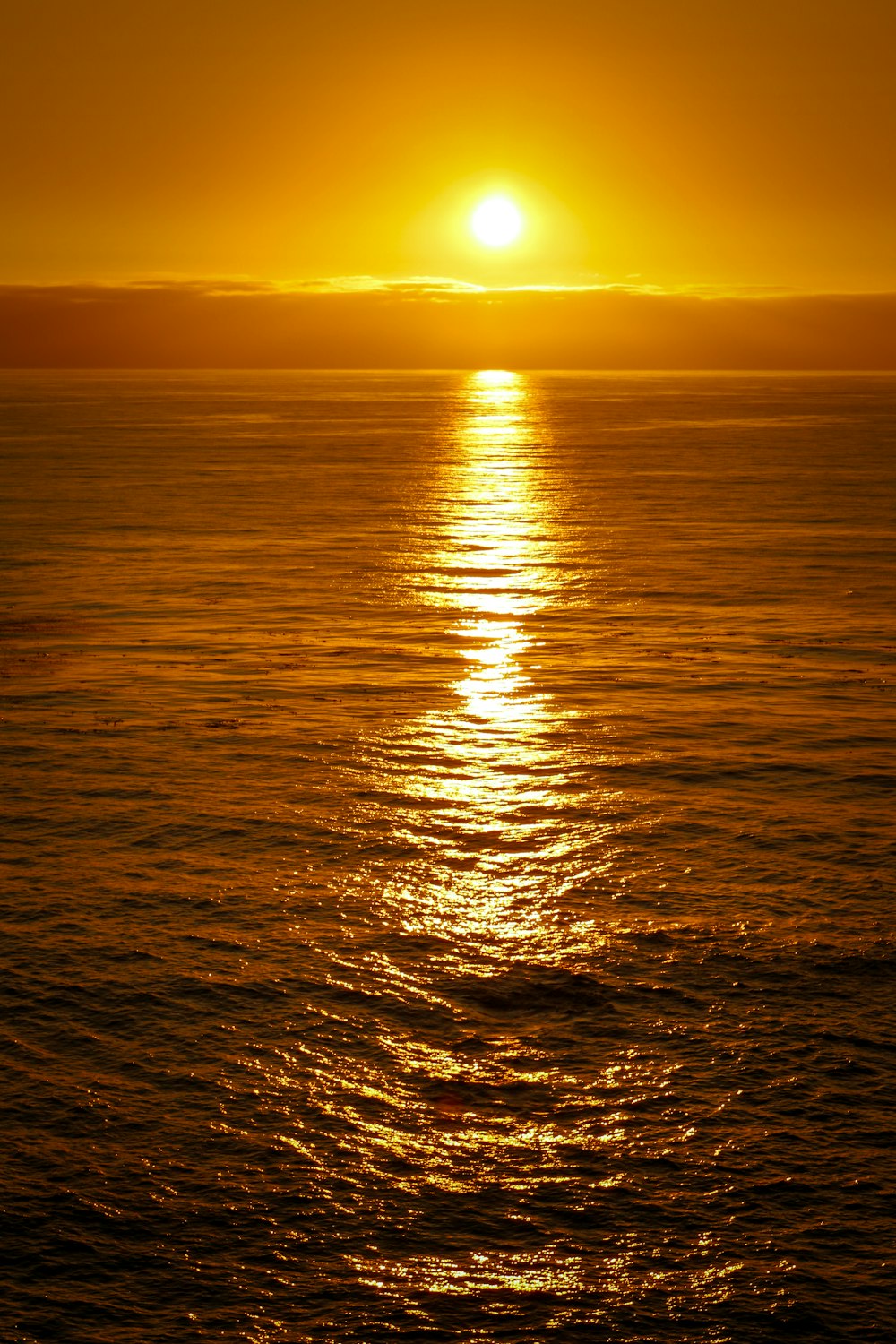 a large body of water with a sunset in the background