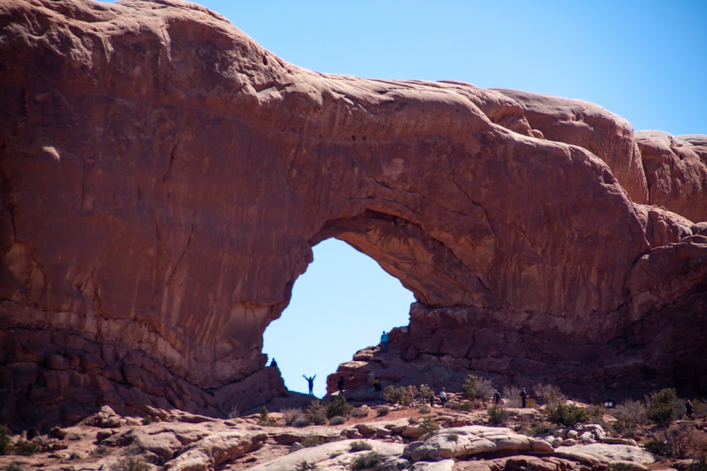 a person standing in front of a large rock formation