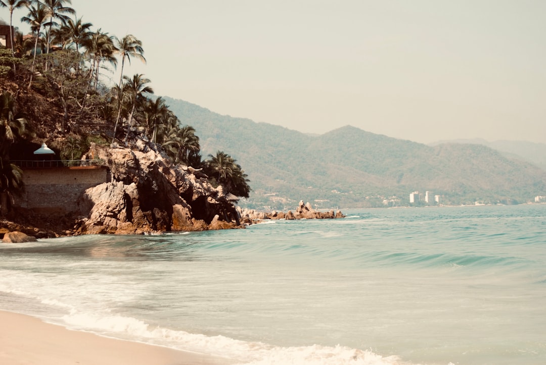 a view of a beach with a mountain in the background, Mexico, Puerto Vallarta Beach