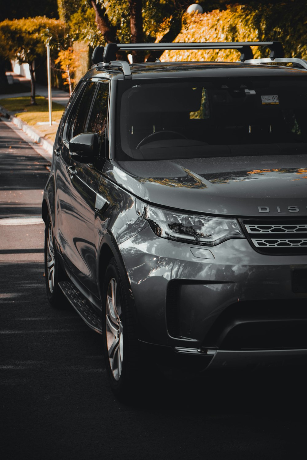 a grey land rover is parked on the side of the road