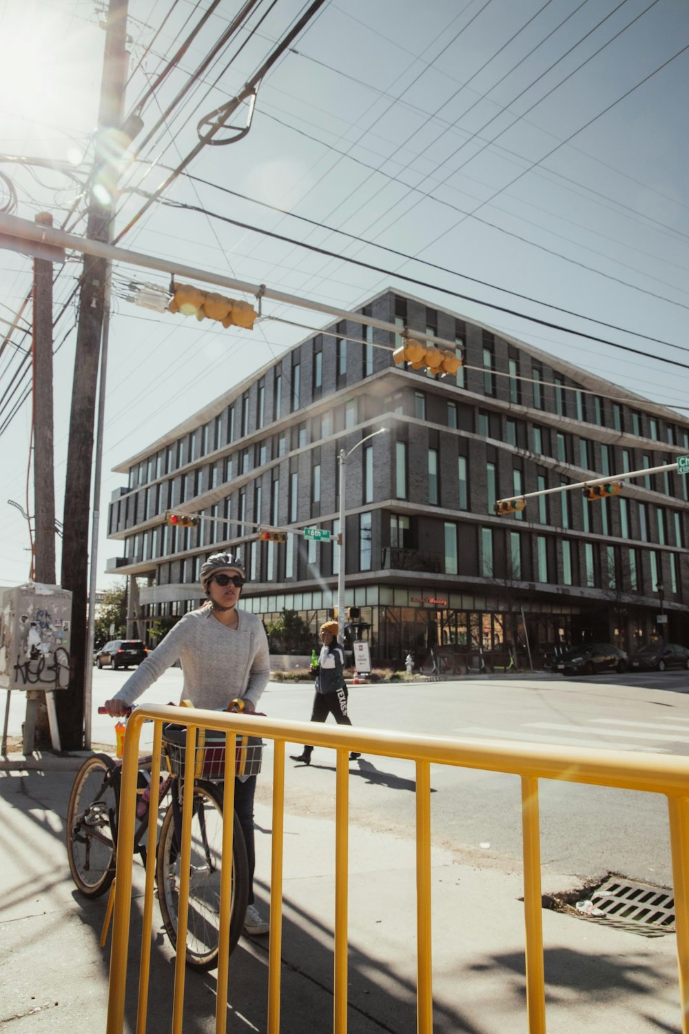 a man riding a bike down a street next to a tall building