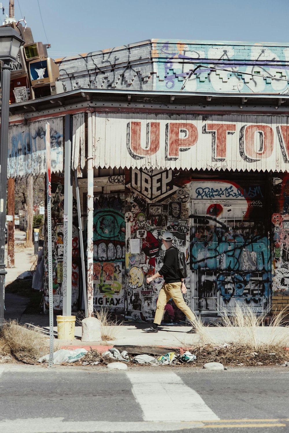 a man walking past a store covered in graffiti