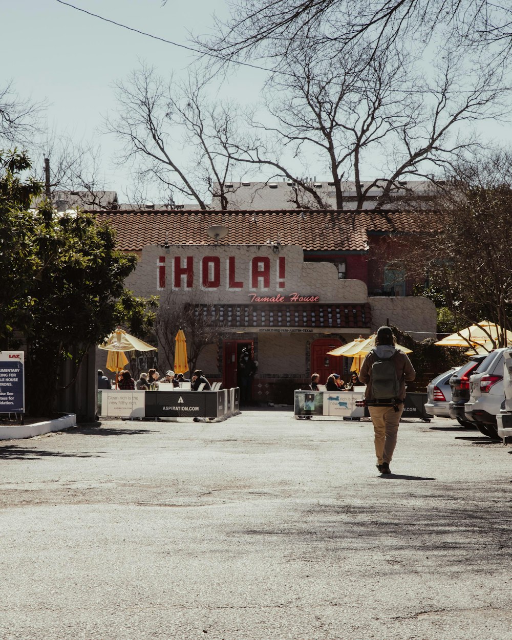 a man walking down a street in front of a restaurant