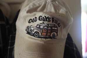 A classic beige trucker hat with mesh back and a vintage patch sewn on.