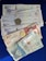 A collection of Colombian banknotes and coins is displayed on a dark blue surface. The notes are of different denominations, including 50,000, 10,000, and 2,000 pesos. Each note features distinct artwork and portraits. Two coins are visible, one silver and one gold in color.