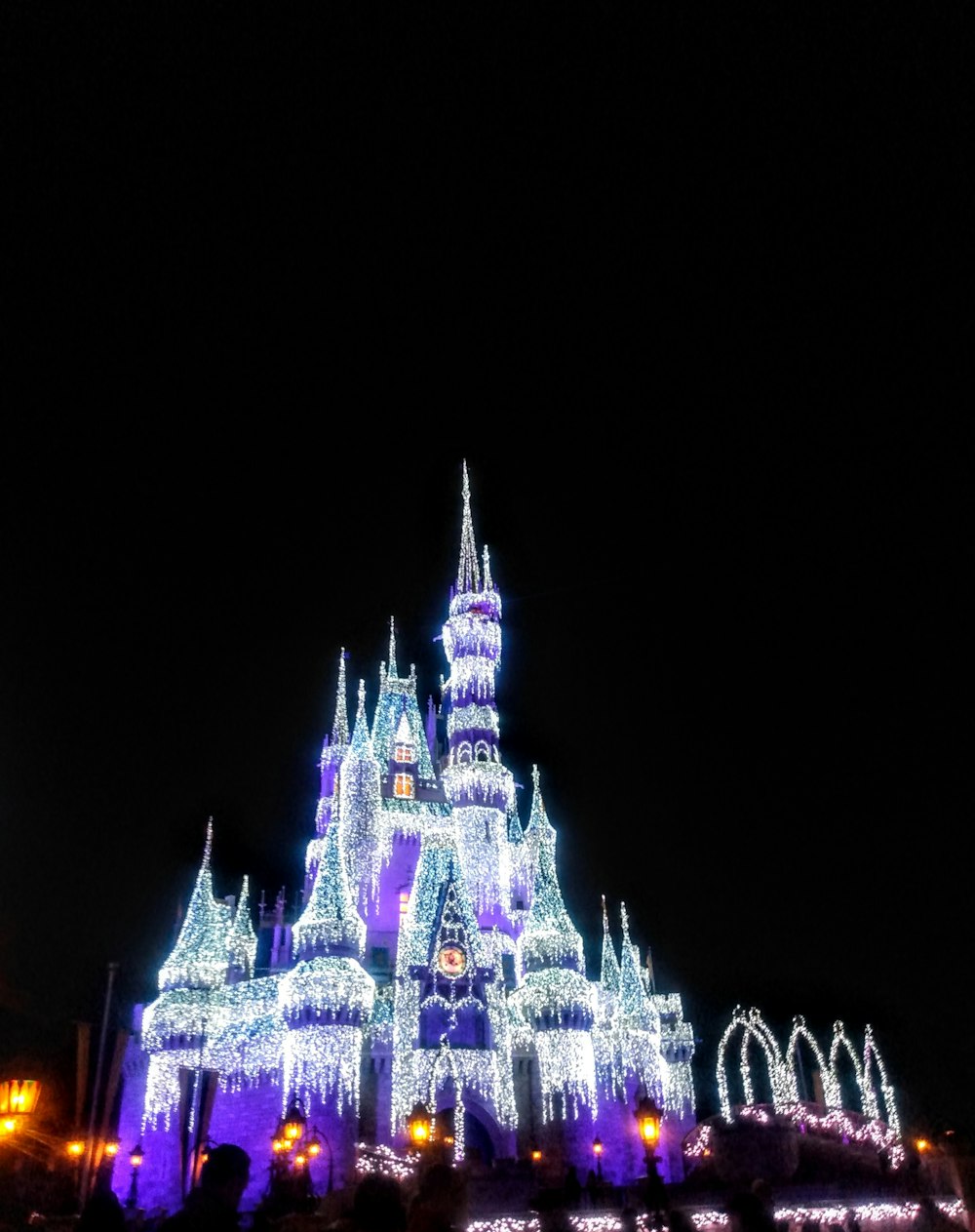 a castle lit up with christmas lights at night