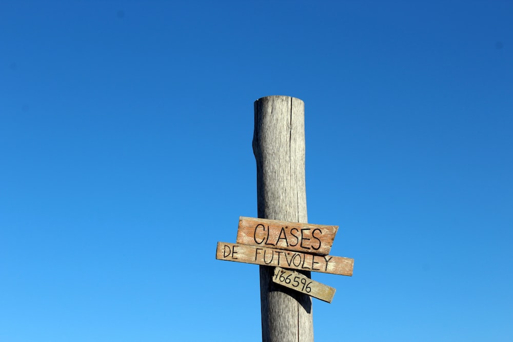 a wooden pole with two wooden signs on it