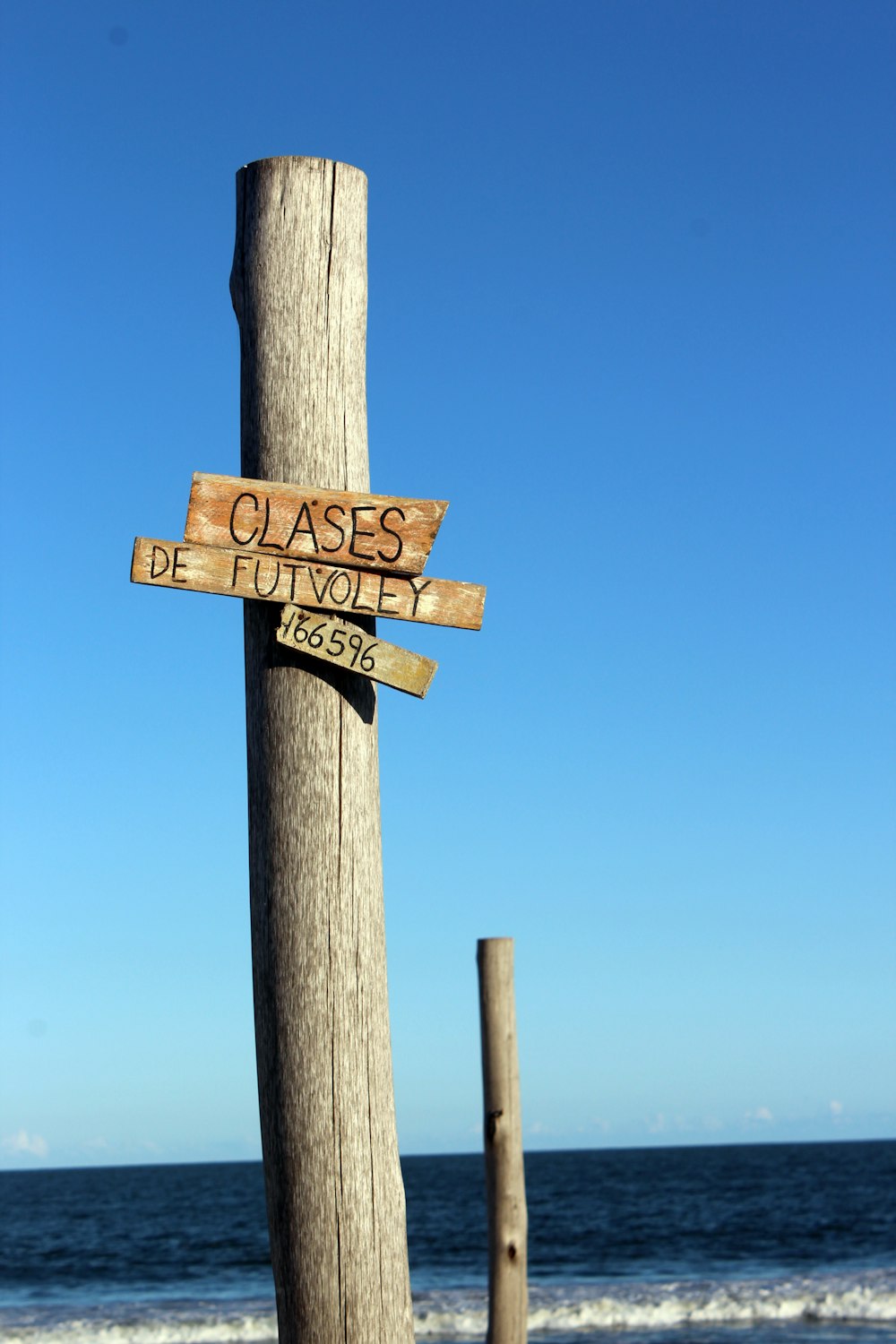 a wooden pole with two wooden signs on it