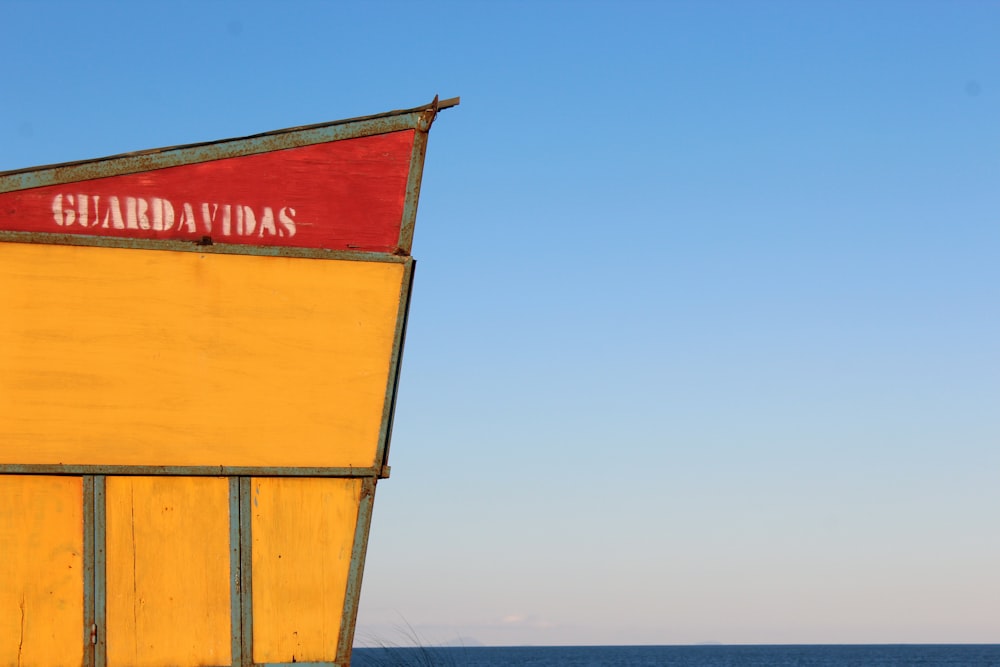 a yellow building with a red sign on top of it