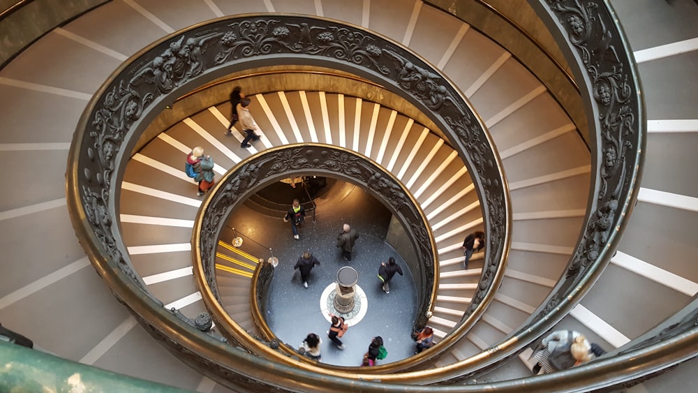 a group of people walking up and down a spiral staircase