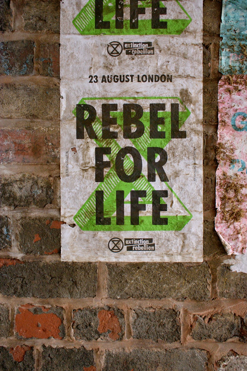 a sign on a brick wall that says rebel for life